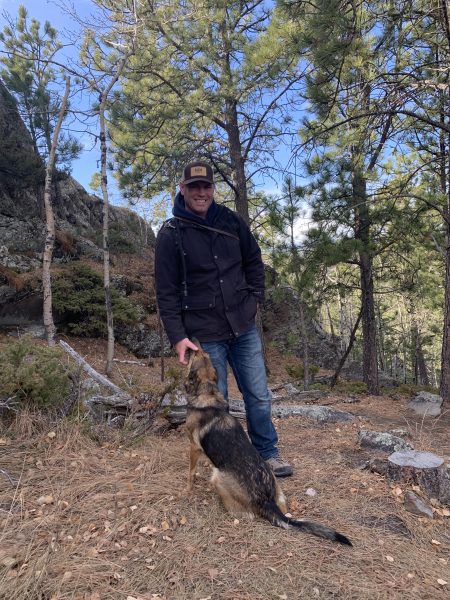 South Dakota Shepinois trainer on hike with dog